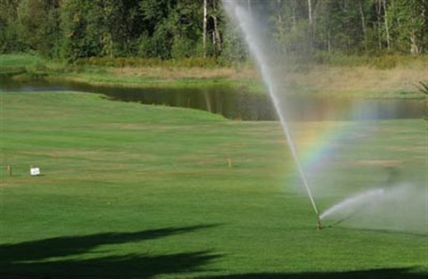Image of sprinklers running on a golf course