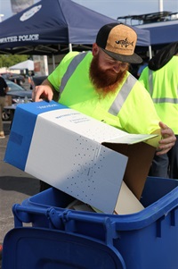 This is a photo of an employee helping residents dispose of old papers at Operation Shred.