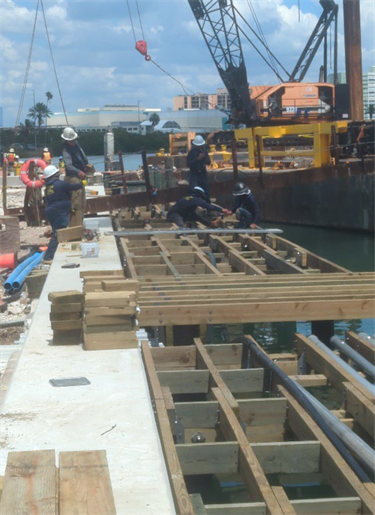 workers laying wooden dock frame 