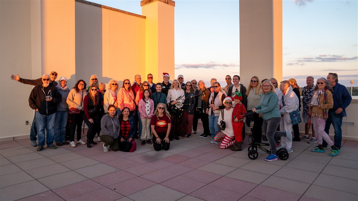 This is an image of a gorup of people on the roof of the main library during a sunset