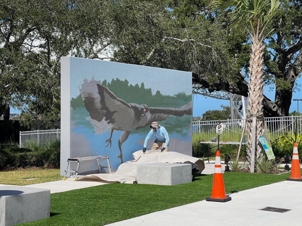 Artist working on osprey mural