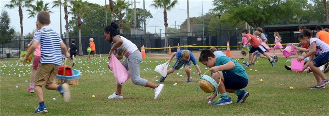 Children are gathering eggs at an Easter egg hunt in the park.