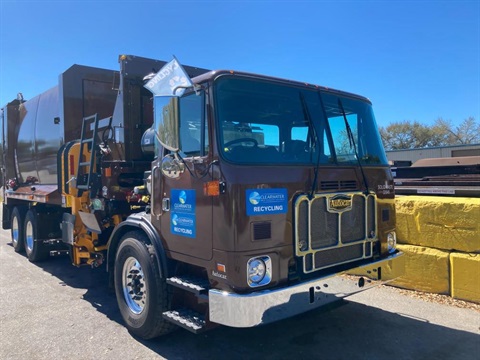 Brown recycling truck with City of Clearwater logo on the door.