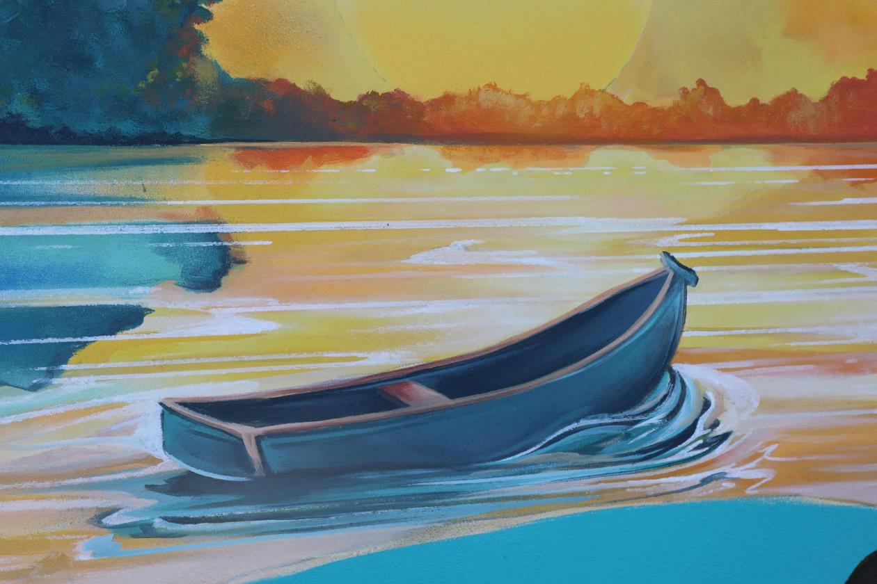 Wall mural of a small row boat in the water at sunset.