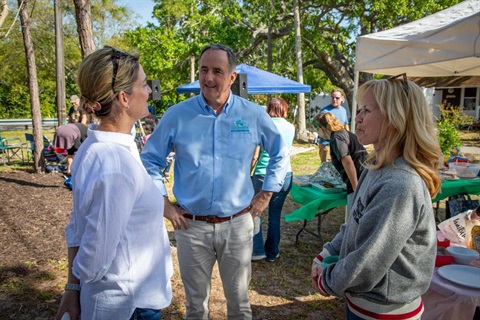 Mayor talking with two ladies at neighborhoods event.